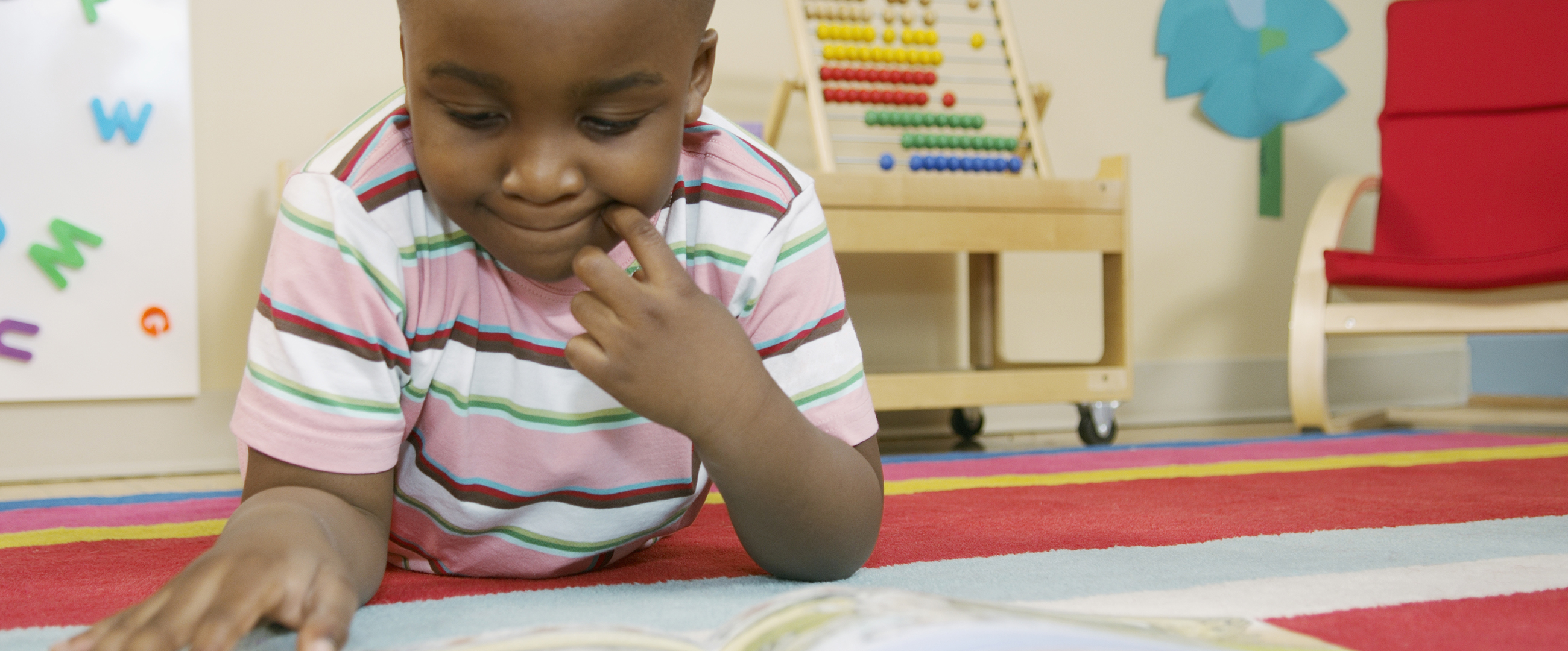 young boy reading in classroom